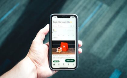 Close-up of a smartphone with a delivery app interface in a person's hand, emphasizing modern e-commerce.